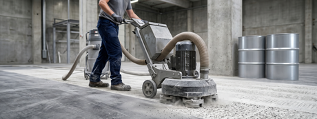 Expert concrete floor preparation showing the mechanical grinding process required before applying heavy-duty epoxy or polyurethane coatings.